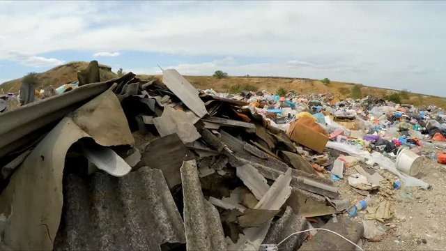 the camera moves away from the dump. Slow motion.