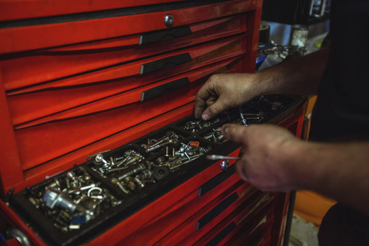Mechanic removing nuts from tool box