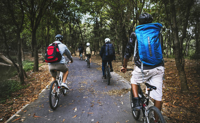 Group of friends ride mountain bike in the forest together