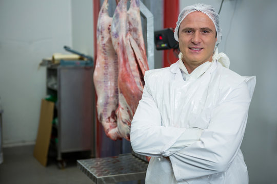 Portrait of butcher standing with arms crossed