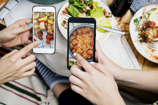 People sharing food photos on mobile phone