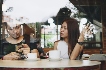 Couple using a phone at a cafe