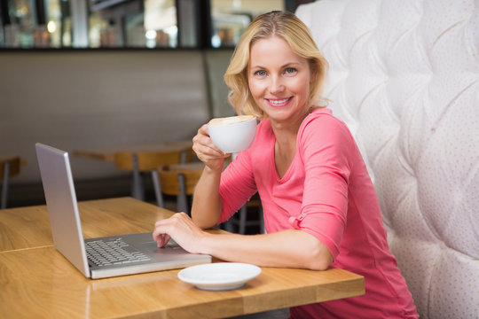 Woman having a coffee using laptop