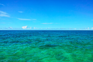Fototapeta na wymiar 真夏の宮古島、来間島のプライベートビーチの前に広がるエメラルドグリーンの海 