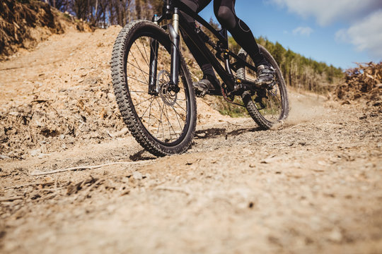 Low section of biker riding on dirt road