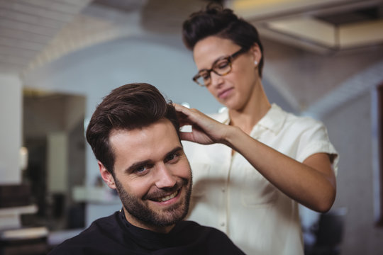 Smiling man getting his hair trimmed at the hair salon