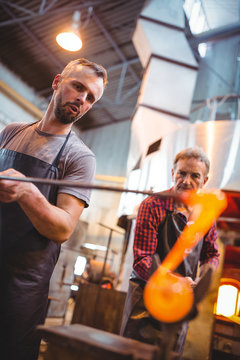 Glassblower shaping a molten glass