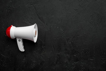 Announcement concept. Megaphone on black background top view copy space