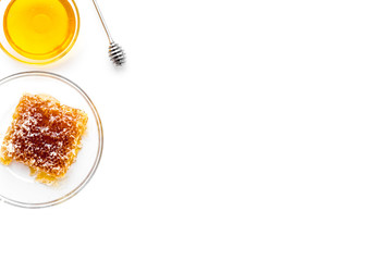 Apiary products. Honey in bowl and honeycomb on white background top view copy space