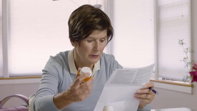 Senior woman reading prescription drug instructions
