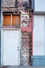 Fototapeta na wymiar Aging window and door in a brick building in downtown Anniston, Alabama, USA