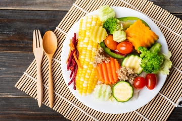 Vegetables salad with wooden spoon and fork, top view of food
