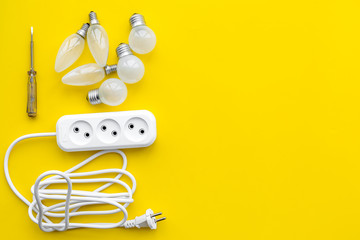 Electrical installation, wiring works. Bulbs and socket outlet on yellow background top view copy...