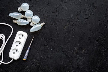 Electrical installation, wiring works. Bulbs and socket outlet on black background top view copy...