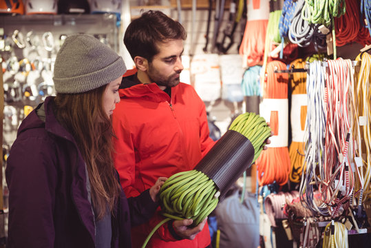 Couple looking at climbing rope in a shop