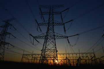 Fototapeta premium The silhouette of the evening electricity transmission pylon