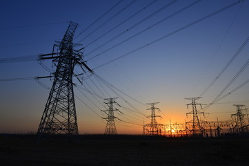 Fototapeta premium The silhouette of the evening electricity transmission pylon