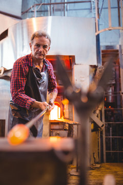 Glassblower shaping a molten glass