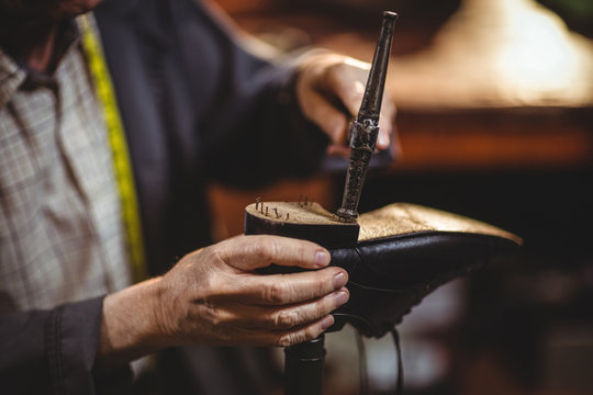 Close up of cobbler hammering on shoe in workshop