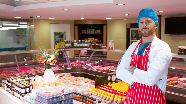 Butcher standing in meat shop with his hands crossed