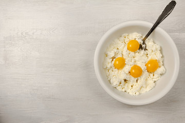 White bowl with ingredients for cheese cake.