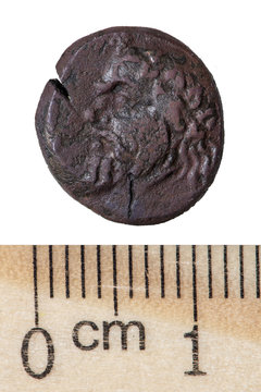 An antique copper coin (halk) of the Bosporus Kingdom of Panticapaeum with the image of a satyr and sturgeon head. Obverse. Isolated on white