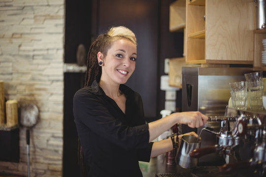Portrait of waitress using the coffee machine