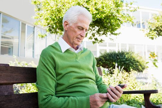 Senior man texting someone