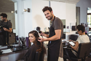 Woman getting her hair dried with hair dryer at the hair salon