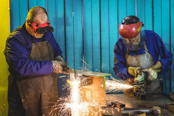 Male and female welders working in workshop