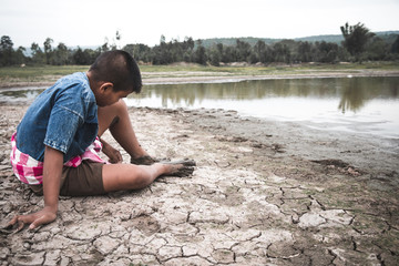 Men on ground cracked dry due to drought, food shortages and water,  Concept drought and crisis environment.