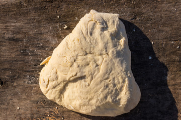 Raw fresh yeast dough for baking on rustic wooden table