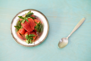 Ripe strawberry on silver plate