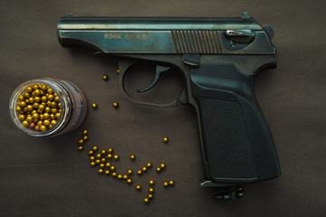 pneumatic gun with pellets on a black background