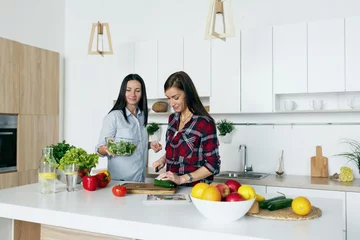 Crédence de cuisine en verre imprimé Cuisinier Healthy lifestyle Happy friends talking cooking vegetable home kitchen