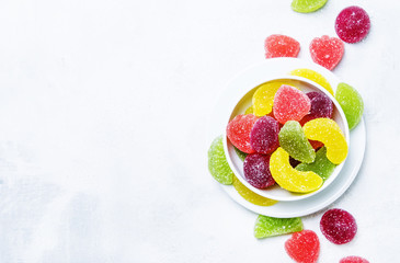 Multicolored marmalade in sugar, light background, top view