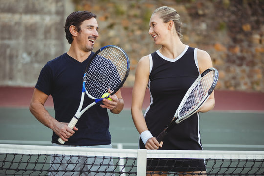 Happy tennis players standing with racket