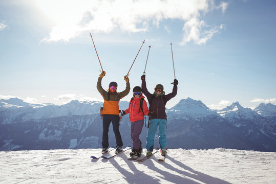 Celebrating skiers standing on snow covered mountain
