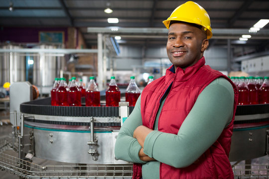 Confident male worker wearing red jacket at juice factory