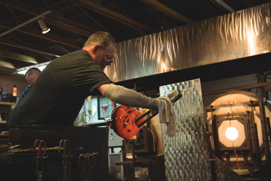 Glassblower shaping a molten glass