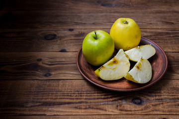 applles on the plate on wooden background