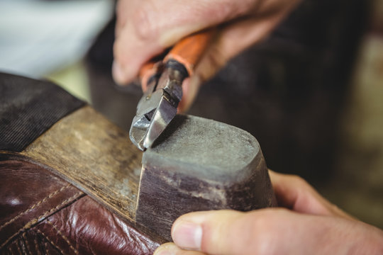 Close-up of shoemaker repairing a shoe