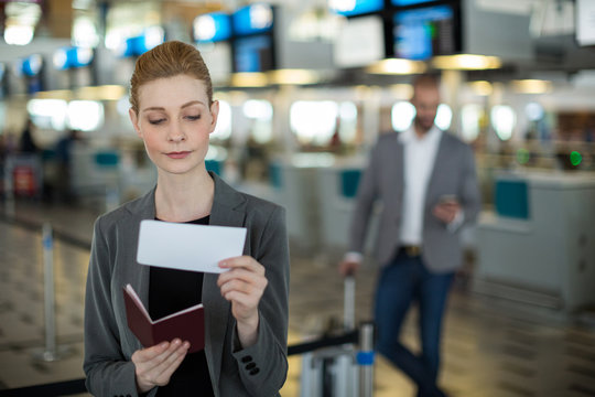 Smiling businesswoman checking her boarding pass