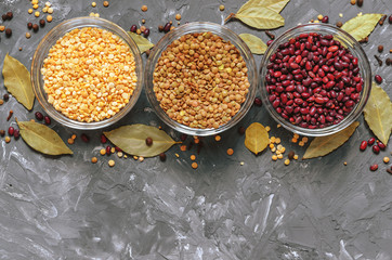 Cereal beans in glass cups: beans, peas and lentils, with spices top view, free space for text