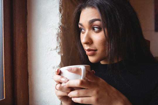 Beautiful woman having a cup of coffee in café - Powered by Adobe