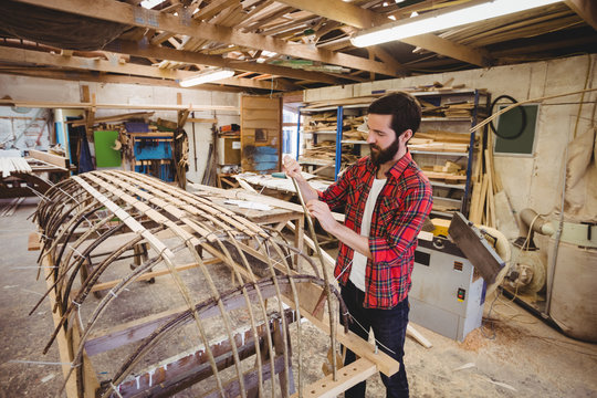 Man preparing wooden boat frame