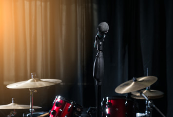 Fototapeta na wymiar Microphone and drums on dark background