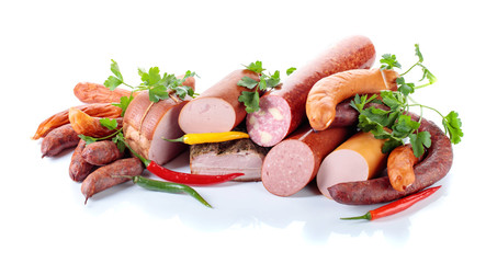 Different sausages and smoked meats isolated on white .