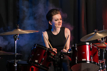 Fototapeta na wymiar Female drummer at drumset in club
