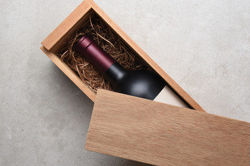 A single bottle of red wine in a wood box